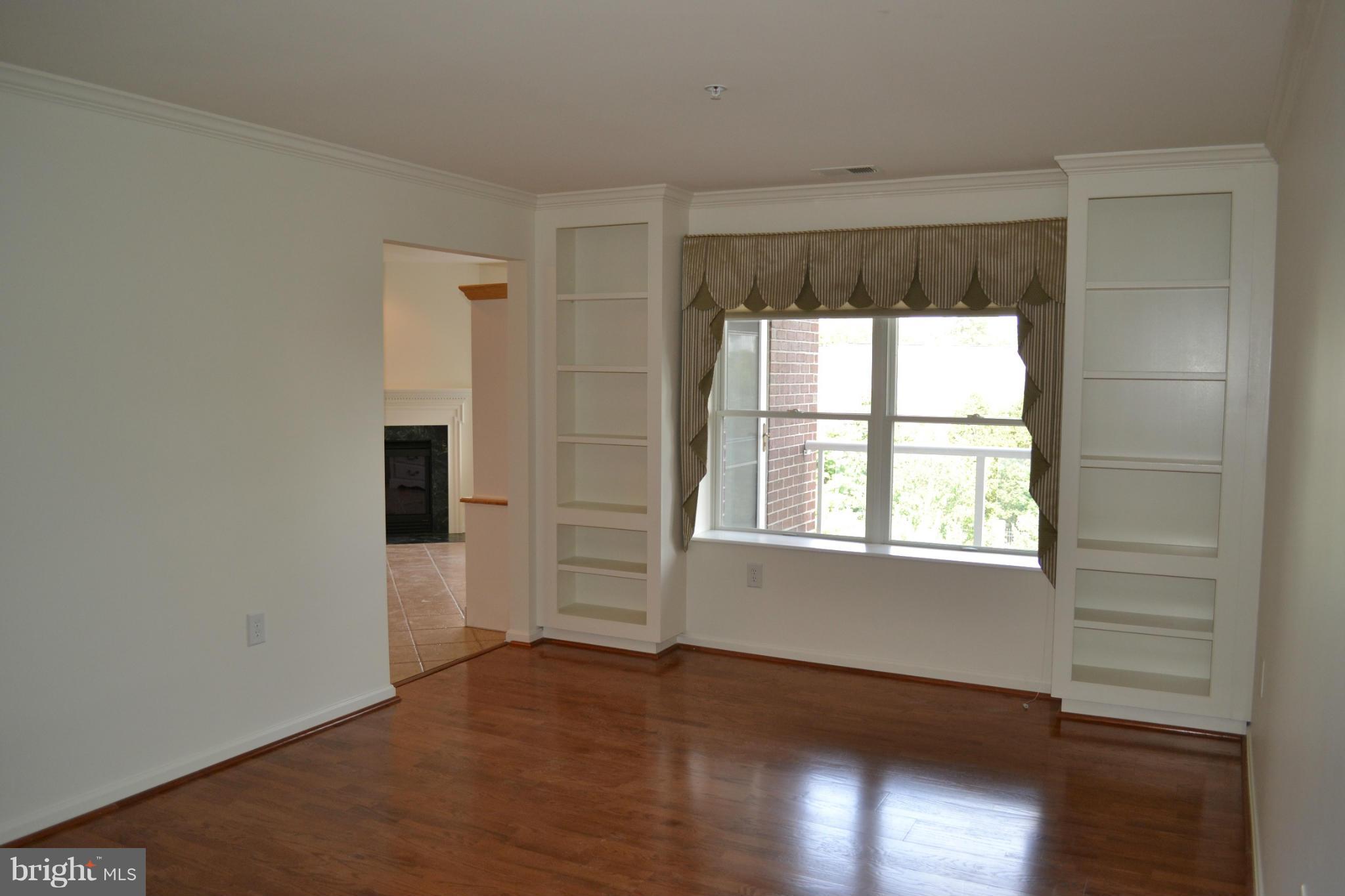 12246 Roundwood Road, Unit 405 Lutherville-Timonium, MD 21093 - Photo 10 of 16 an empty room with wooden floor and windows