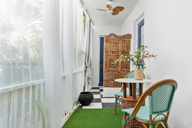 a front view of a house with wooden floor and a potted plant
