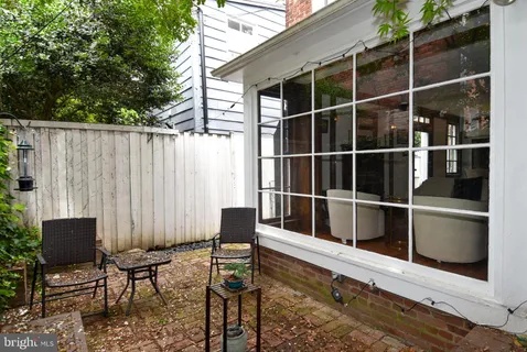 a view of a chairs and table in the back yard