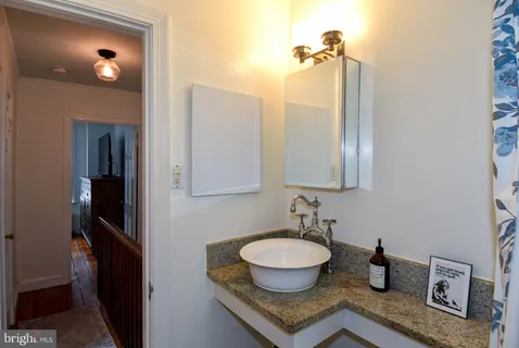 a bathroom with a granite countertop sink and a mirror