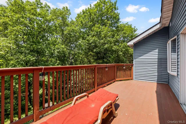 a balcony with wooden floor and outdoor seating