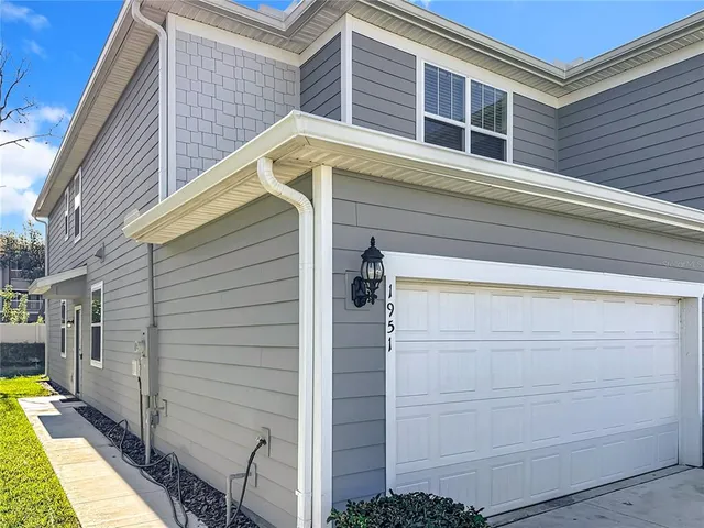 a front view of house with yard and trees in the background