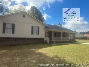 a view of house with backyard space and balcony