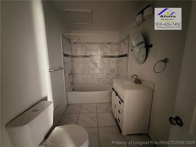 a bathroom with a granite countertop sink a toilet and shower