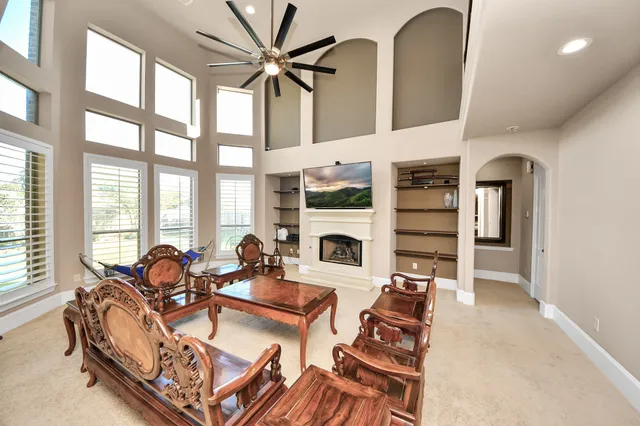 a living room with fireplace furniture and a large window