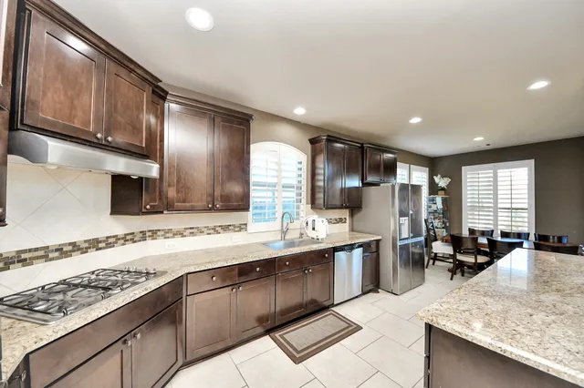 a kitchen with stainless steel appliances granite countertop a sink stove and cabinets