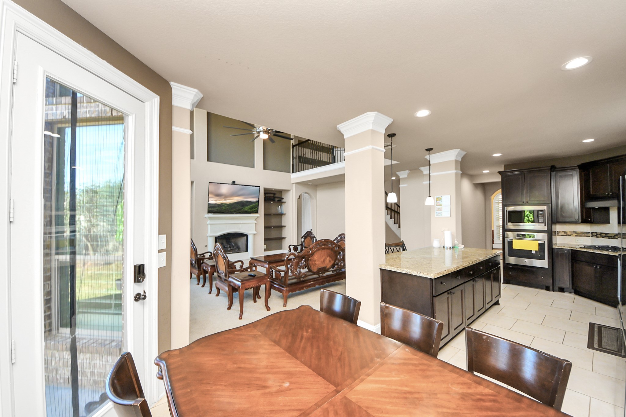 8447 Roland Canyon Drive Cypress, TX 77433 - Photo 21 of 41 a living room with stainless steel appliances kitchen island granite countertop a table chairs and a view of living room