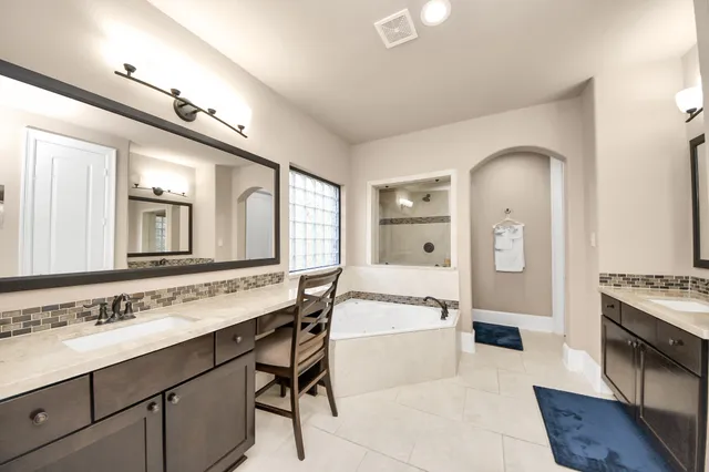 a spacious bathroom with a sink double vanity and a mirror