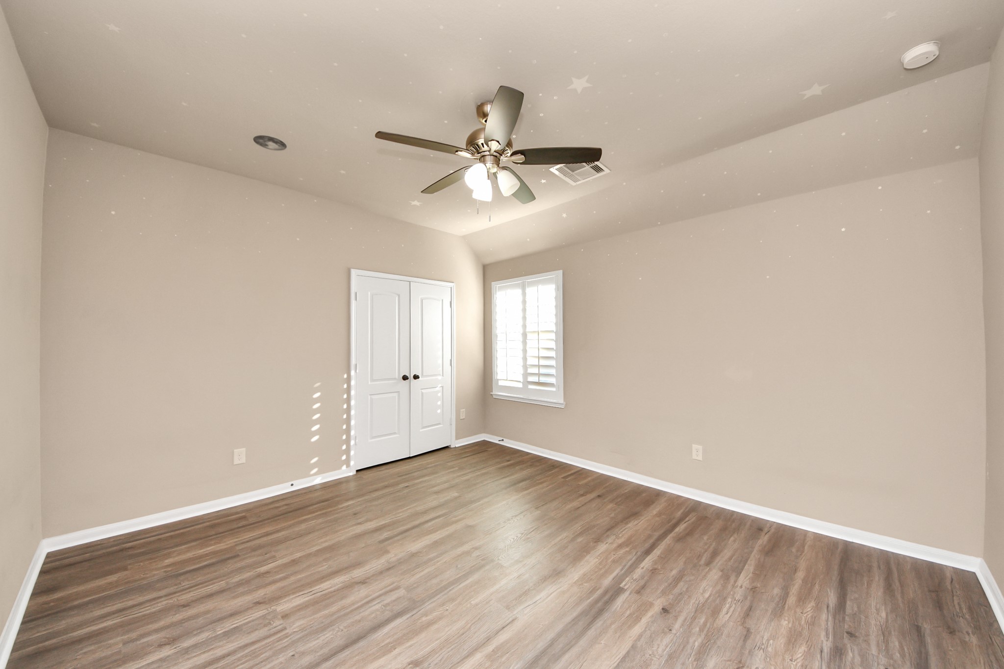 8447 Roland Canyon Drive Cypress, TX 77433 - Photo 37 of 41 an empty room with wooden floor ceiling fan and windows