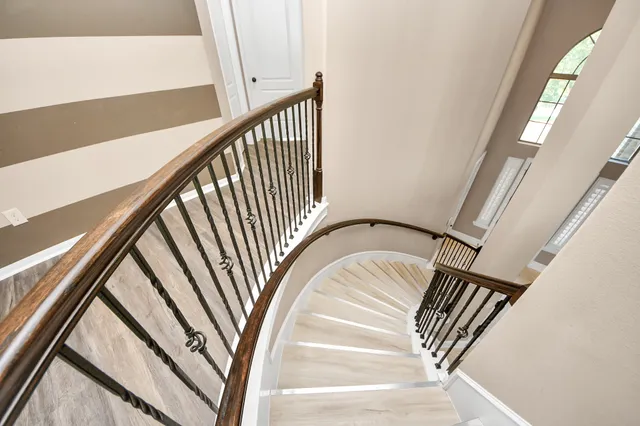 a view of staircase with railing and white walls