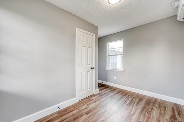 a view of an empty room with wooden floor