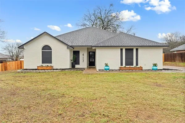 a front view of house with yard and trees