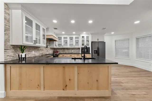 a large kitchen with stainless steel appliances granite countertop a granite counter tops and a stove