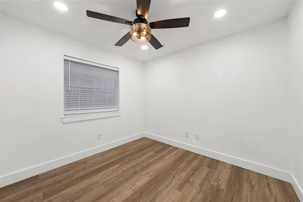 an empty room with a window and ceiling fan