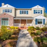 a front view of a house with a yard and potted plants