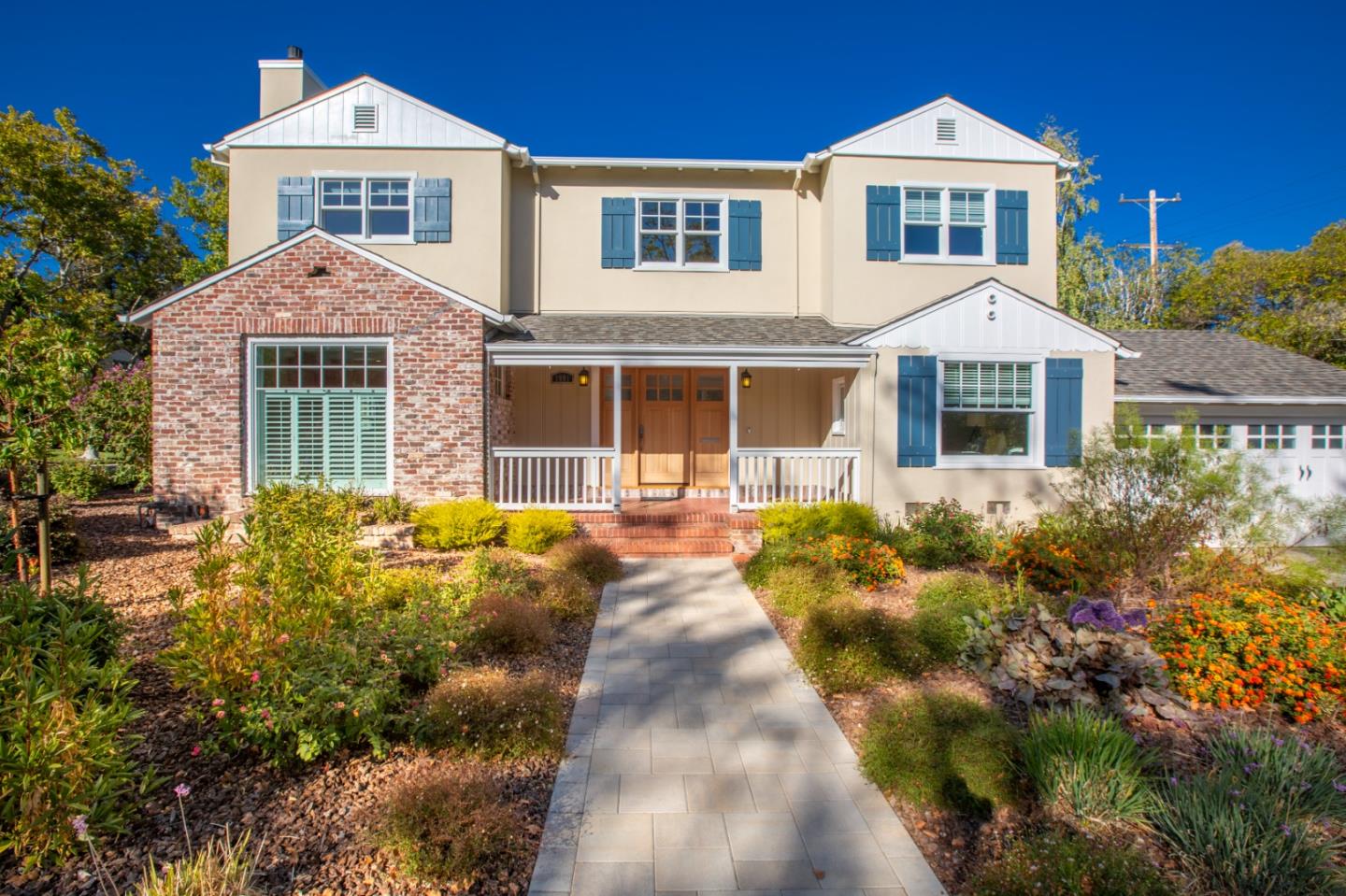 a front view of a house with a yard and potted plants