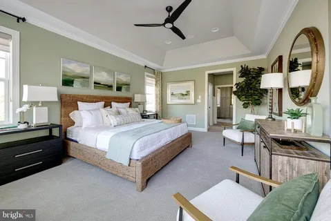 a spacious bedroom with a bed a table window and couch