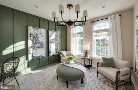a living room with furniture a chandelier and a large window