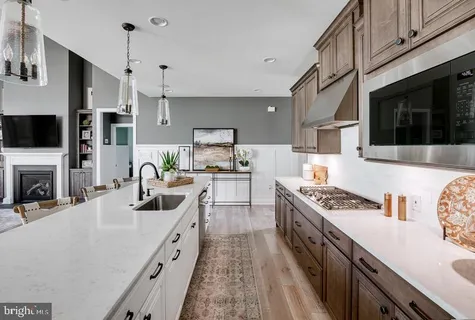 a kitchen with stainless steel appliances a stove a sink a microwave and cabinets
