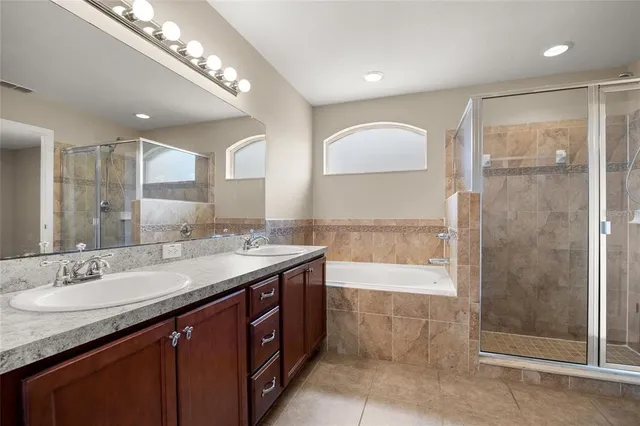 a bathroom with a granite countertop sink a mirror and a shower