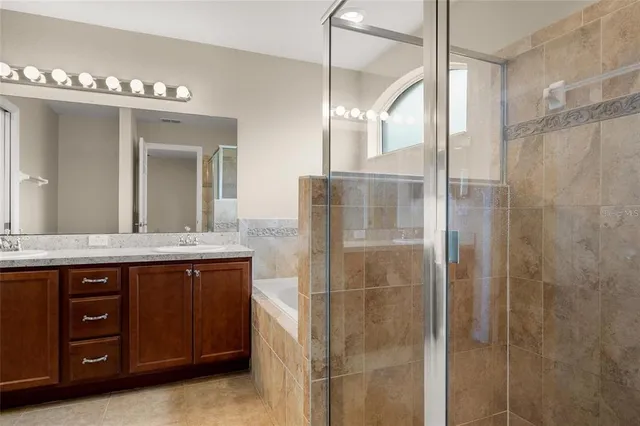 a bathroom with a granite countertop sink a large mirror and a shower