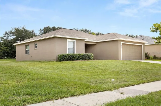 a front view of house with yard and trees