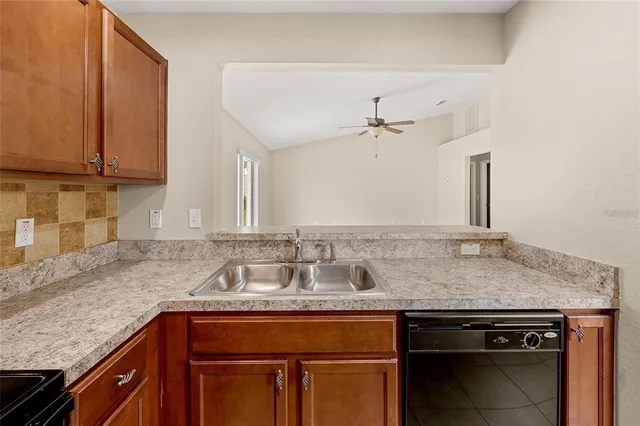 a kitchen with granite countertop a sink and cabinets