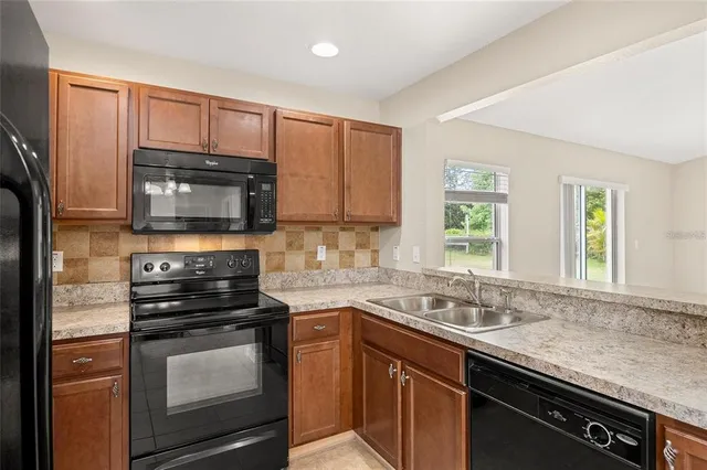 a kitchen with granite countertop a sink and steel appliances