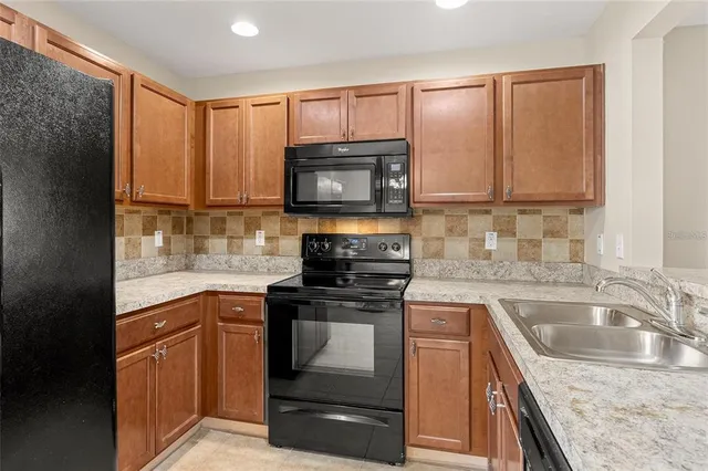 a kitchen with granite countertop a stove sink and microwave