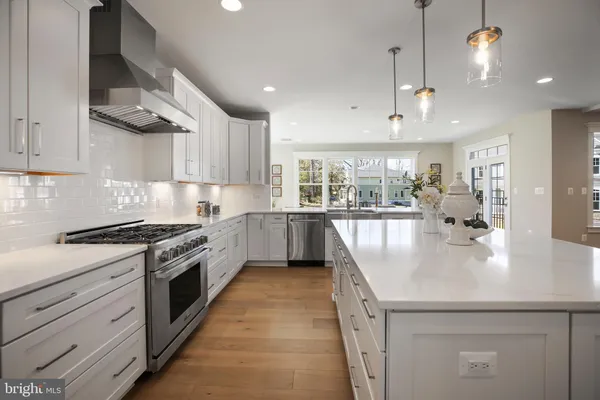 a large kitchen with stainless steel appliances granite countertop a lot of counter space and a sink