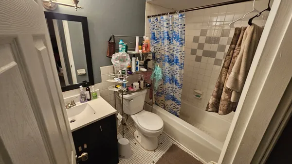 a bathroom with a toilet sink and shower curtain