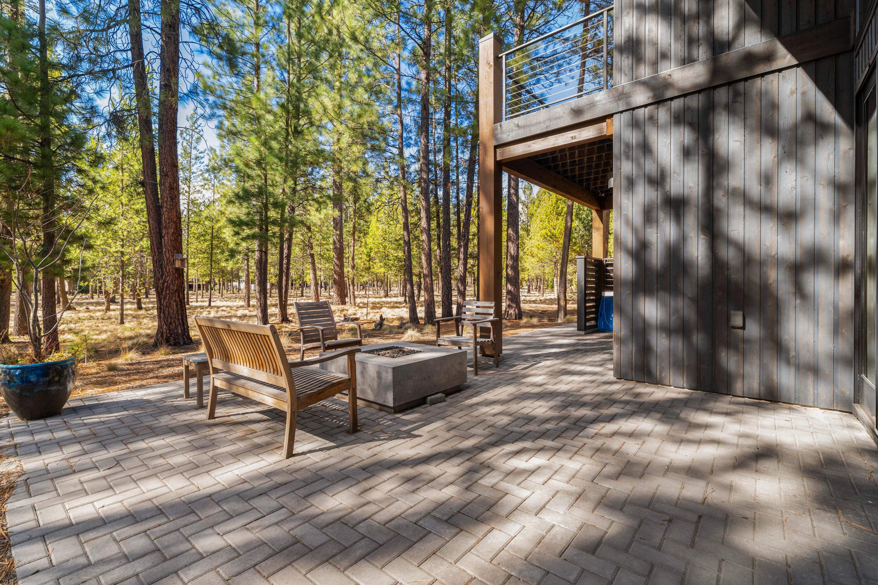 56670 Sunstone Loop, Unit LOT 141 Bend, OR 97707 - Photo 6 of 62 Thoughtfully designed outdoor living space with expansive paver patio, natural gas fire pit, and BBQ area, all set against a peaceful woodland backdrop. A great location close to trails and between the Lakehouse and Forest House amenities.
