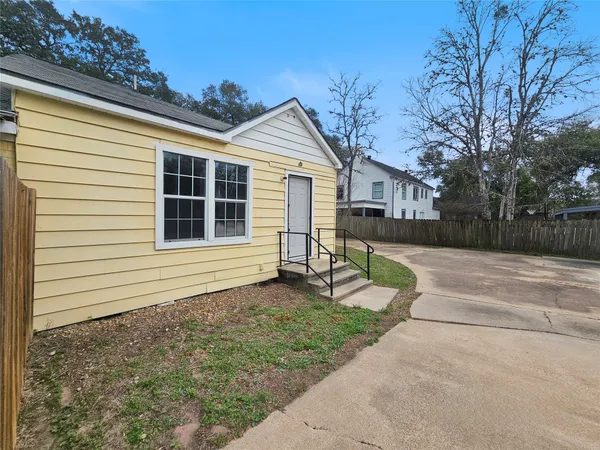 a view of house with backyard and tree