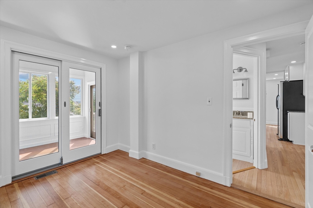 91 Prentice Street Waltham, MA 02451 - Photo 16 of 38 a view of an empty room with wooden floor and a window