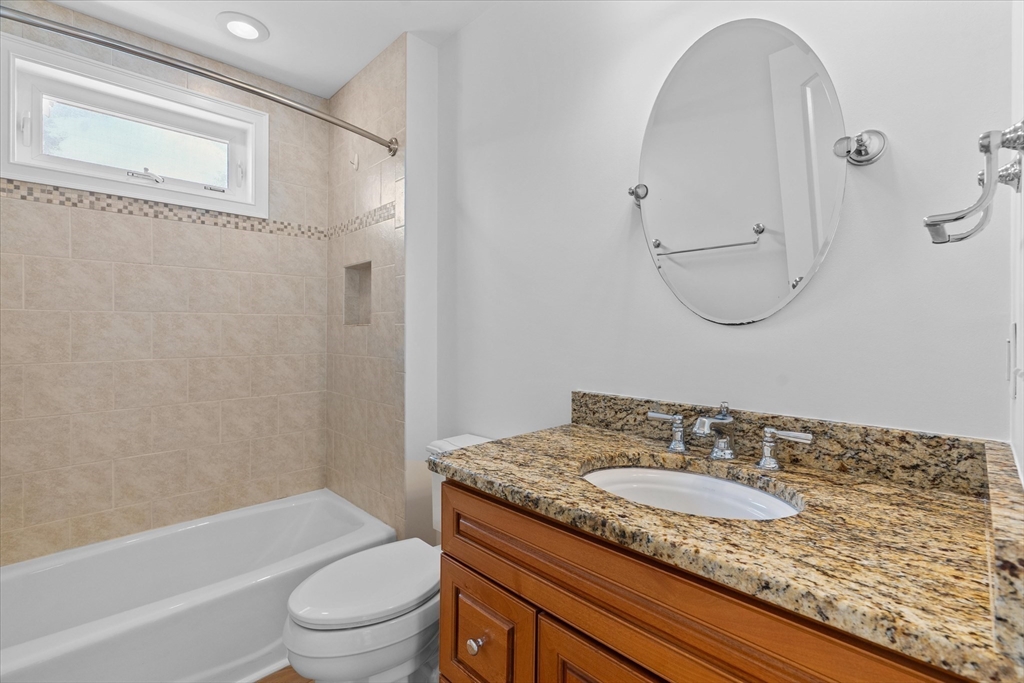91 Prentice Street Waltham, MA 02451 - Photo 30 of 38 a bathroom with a granite countertop sink a toilet and shower