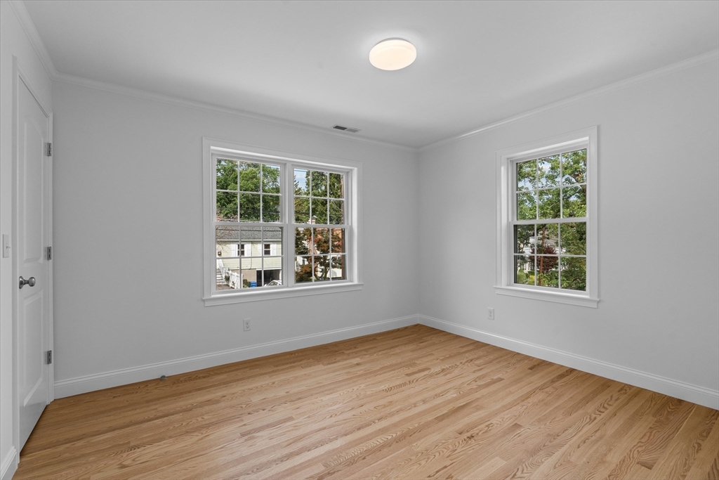 91 Prentice Street Waltham, MA 02451 - Photo 31 of 38 a view of an empty room with wooden floor and a window