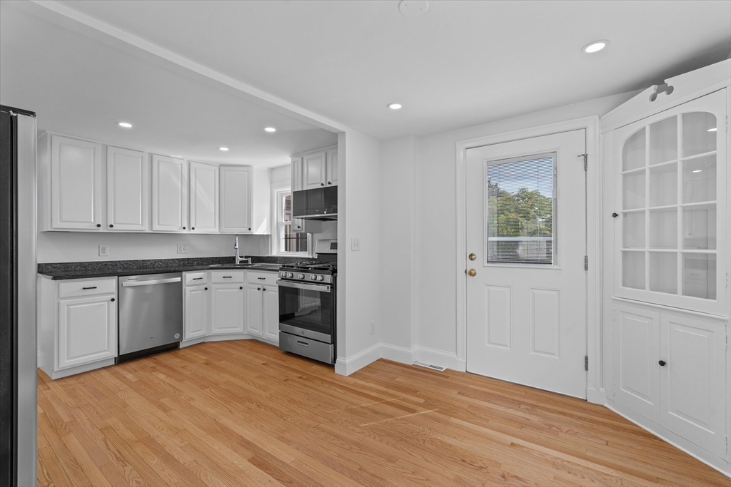 91 Prentice Street Waltham, MA 02451 - Photo 5 of 38 a kitchen with a refrigerator and white cabinets