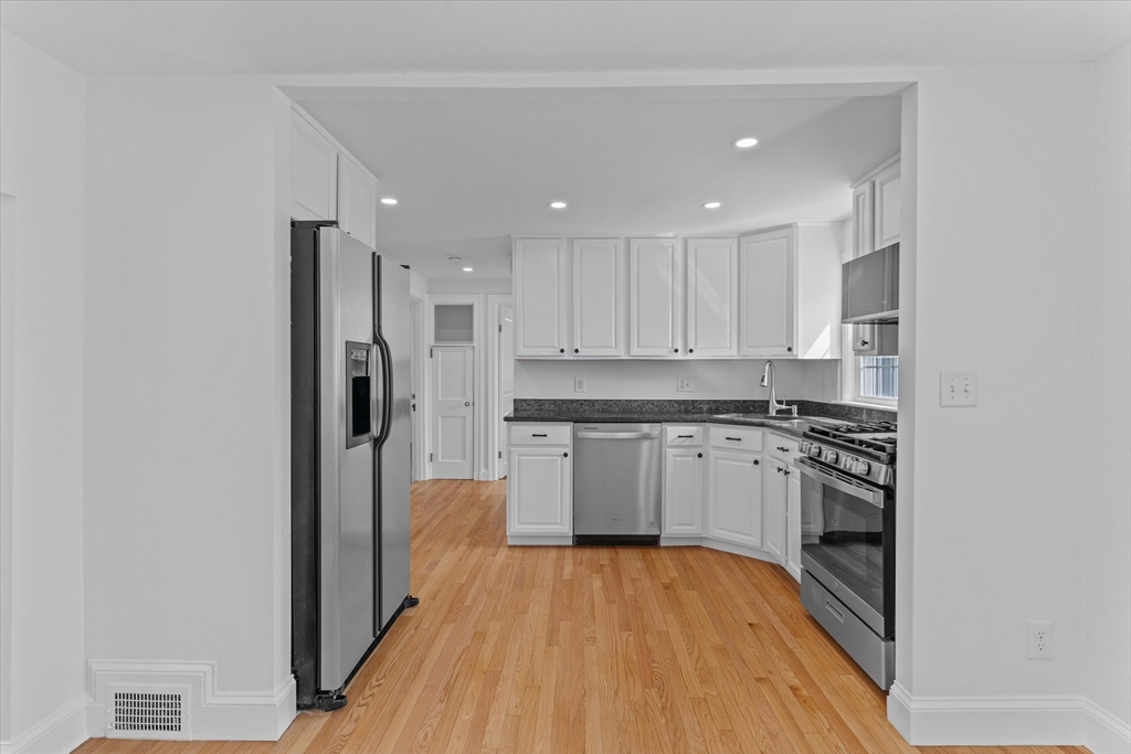 91 Prentice Street Waltham, MA 02451 - Photo 6 of 38 a kitchen with stainless steel appliances granite countertop a refrigerator and a stove top oven