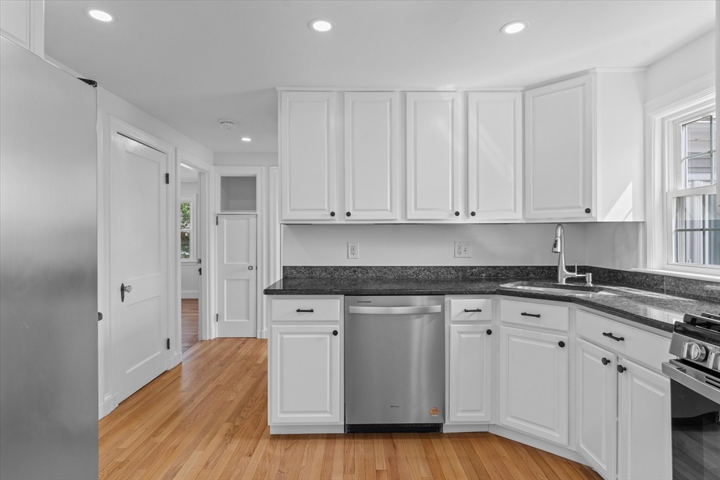 91 Prentice Street Waltham, MA 02451 - Photo 8 of 38 a kitchen with granite countertop white cabinets and white appliances