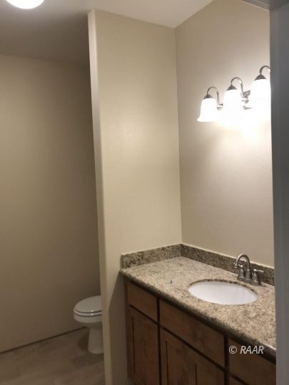 425 Randall Street Ridgecrest, CA 93555 - Photo 17 of 27 a bathroom with a granite countertop sink and a toilet