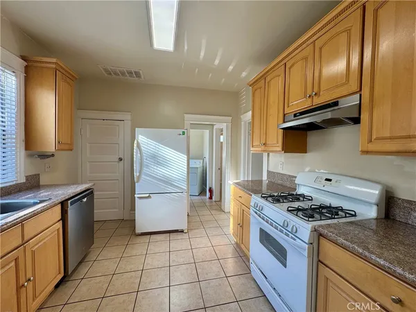 a kitchen with stainless steel appliances granite countertop a stove a sink and a refrigerator