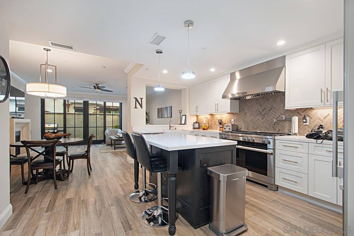712 Silver Street La Jolla, CA 92037 - Photo 6 of 21 a kitchen with stainless steel appliances a dining table chairs stove and cabinets