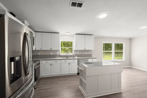 a kitchen that has a sink a window and stainless steel appliances