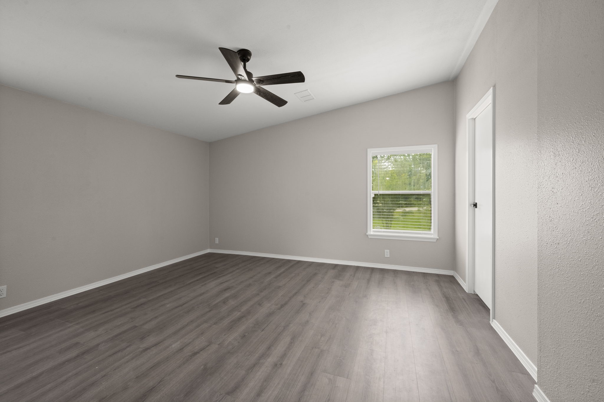 285 County Road 388 Cleveland, TX 77328 - Photo 15 of 23 an empty room with wooden floor fan and windows