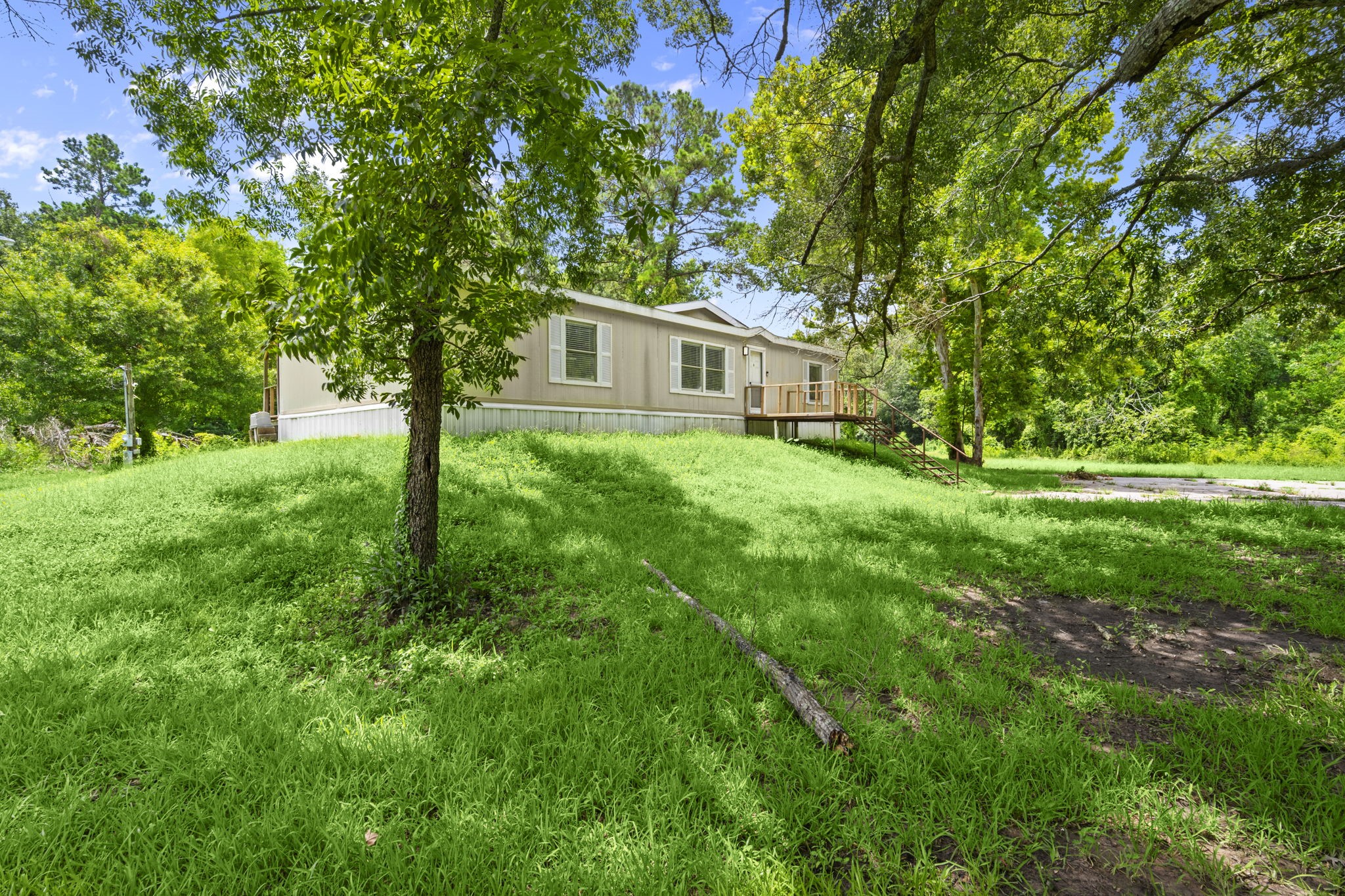 285 County Road 388 Cleveland, TX 77328 - Photo 4 of 23 a yellow house in middle of the forest