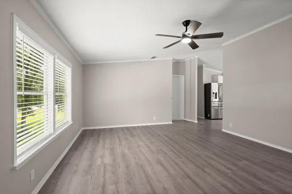 a view of empty room with wooden floor and ceiling fan