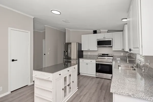 a kitchen with white cabinets and stainless steel appliances