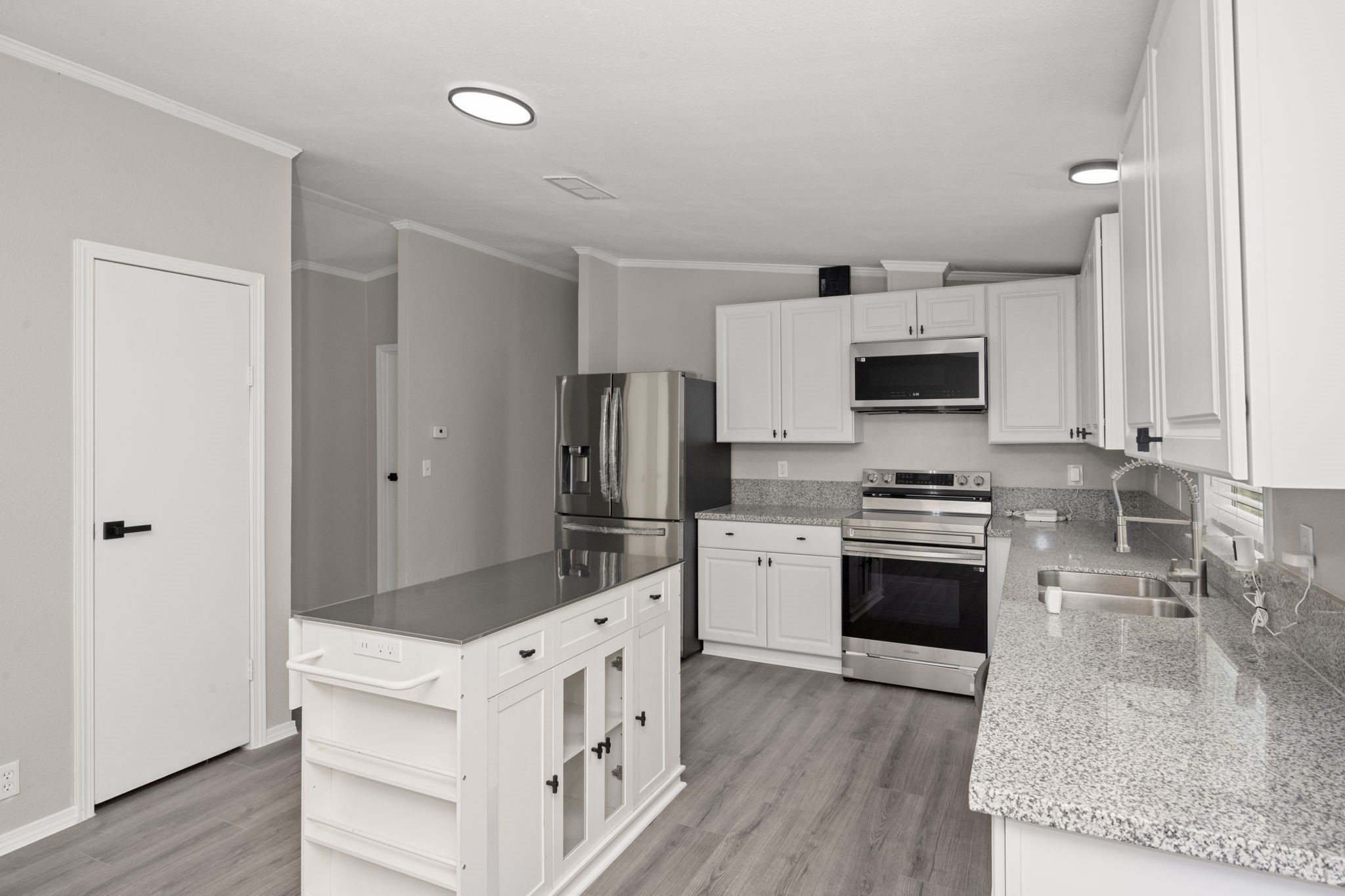 285 County Road 388 Cleveland, TX 77328 - Photo 10 of 23 a kitchen with white cabinets and stainless steel appliances