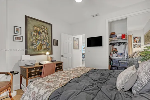 a bedroom that has a bed and a flat screen tv