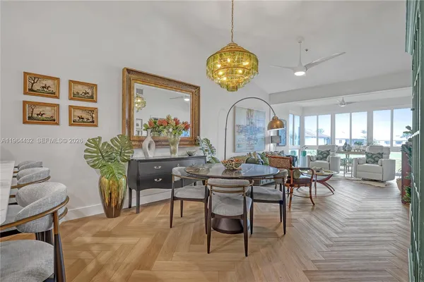 a view of a dining room with furniture a chandelier and wooden floor